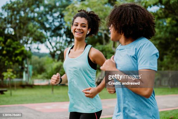 two teenage girl friends running, exercising - on the move imagens e fotografias de stock