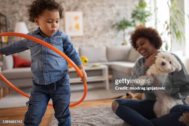 multiracial family with maltese dog playing in the living room - mom and baby animal stock pictures, royalty-free photos & images