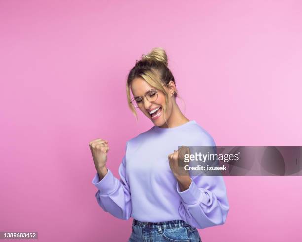 cheerful woman with clenched fists - succes stockfoto's en -beelden