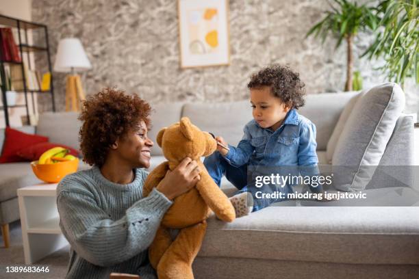 menino criança alimentando ursinho de pelúcia com chocolate - mama bear - fotografias e filmes do acervo