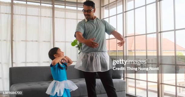 i love you, dad - handsome young man is dancing at home with his little cute girl. happy fathers day - mini dress photos et images de collection