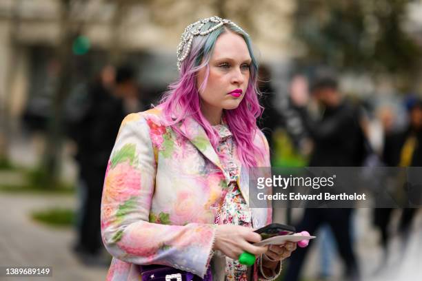 Guest wears a pale pink / orange / green / blue flower print pattern jacket, a white with multicolored flower print pattern ruffled dress, a pearls...