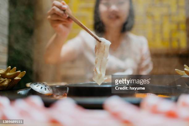 豚肉のスライスを鍋スープで沸騰させるアジアの中国人女性 - szechuan cuisine ストックフォトと画像