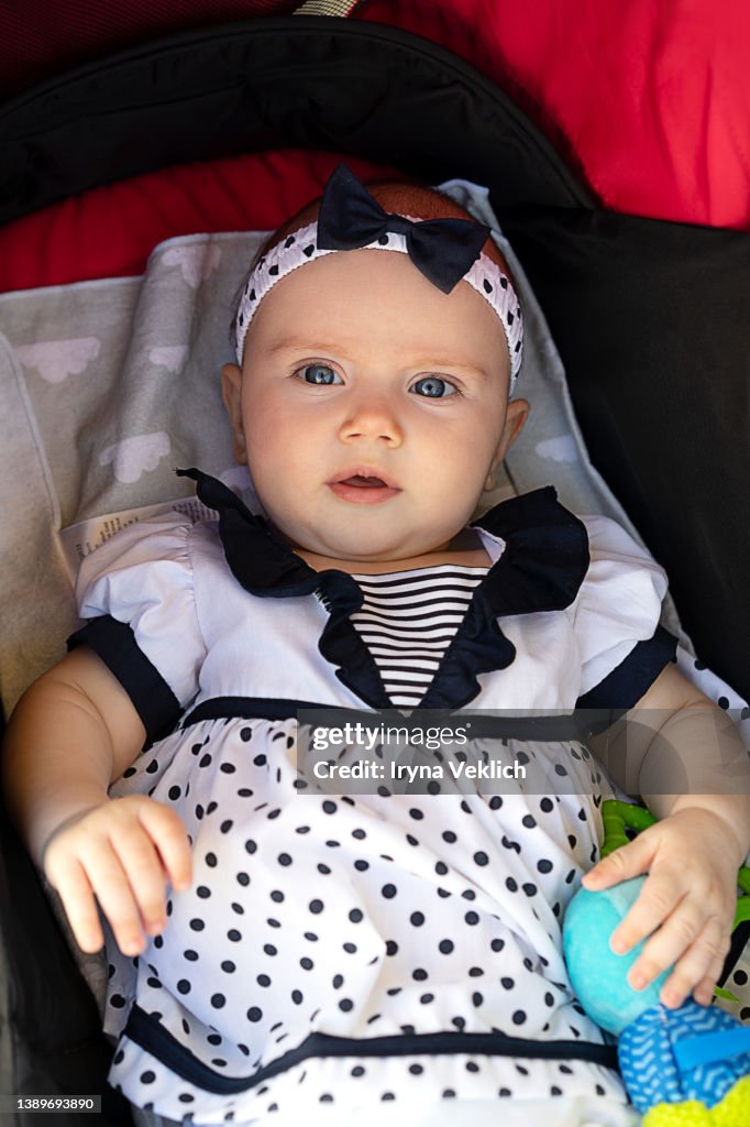 Happy adorable baby girl beautifully dressed in a sailor suit on summer vacation.