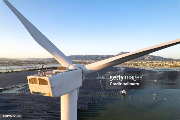 aerial view of solar power plant by the sea from the perspective of wind turbines - comercio de derechos de emisión fotografías e imágenes de stock