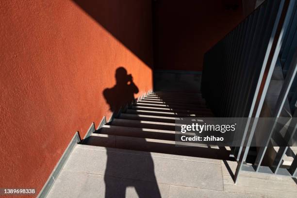 parts of the wall and stairs are illuminated by sunlight, with shadows of people - art from the shadows stockfoto's en -beelden