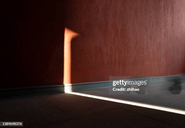 a light on a red concrete wall - luce elettrica foto e immagini stock