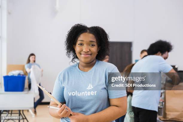 young adult woman poses for a picture at the event - volunteers stock pictures, royalty-free photos & images