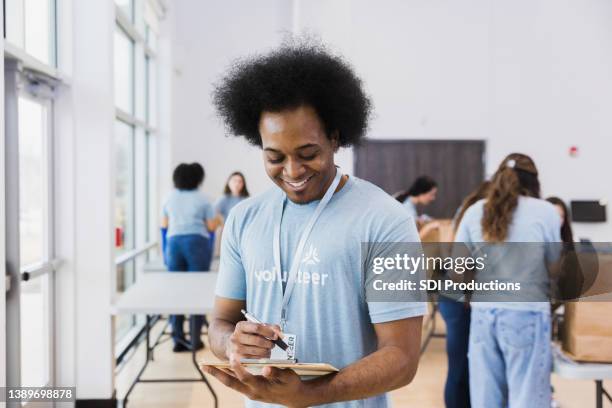 young adult male reading - vrijwilliger bedrijf stockfoto's en -beelden