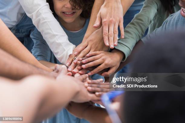 unrecognizeable people in a team huddle - hand stack stock pictures, royalty-free photos & images