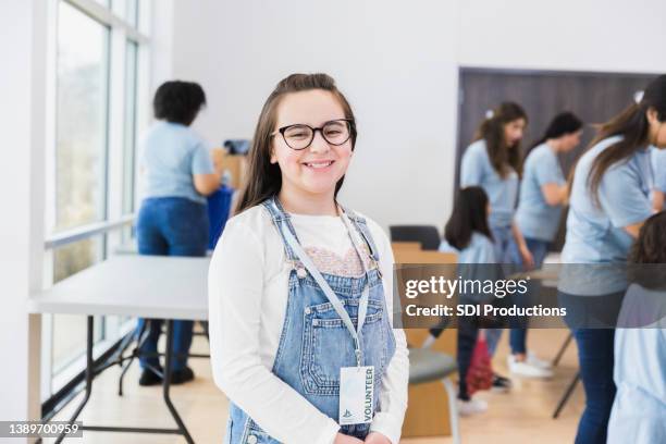 pre-teen girl poses for photo at volunteer event - kids at community center stock pictures, royalty-free photos & images