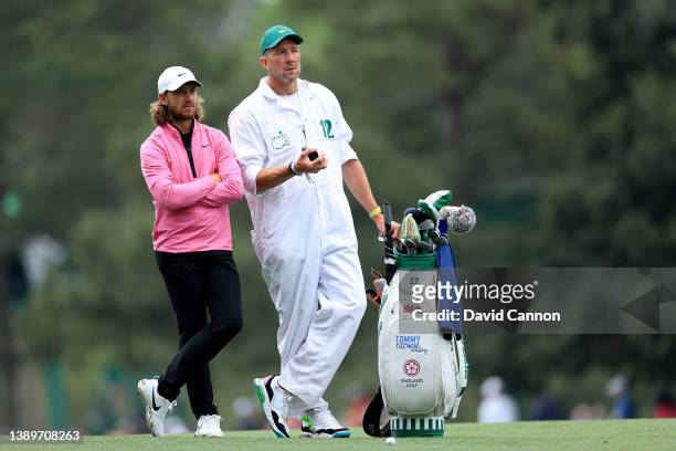 Tommy Fleetwood of England talks with his caddie Ian Finnis on the 15th hole during a practice round prior to the Masters at Augusta National Golf...