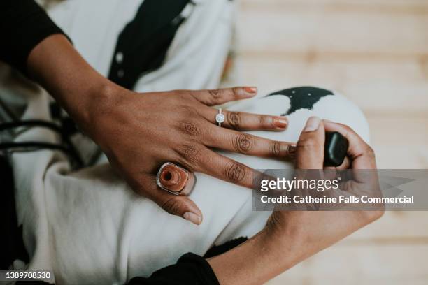 close-up of a black woman painting her fingernails brown - manicure foto e immagini stock
