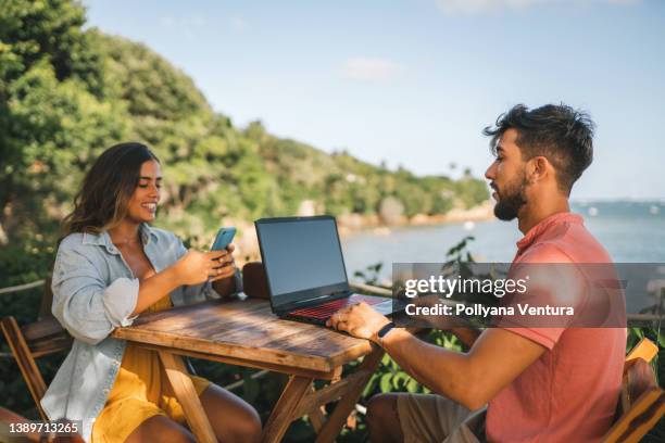 meeting at the tropical restaurant - telecommuting couple stock pictures, royalty-free photos & images