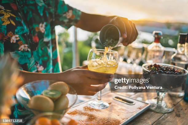 bartender serving a fruit cocktail - tropical cocktail stock pictures, royalty-free photos & images
