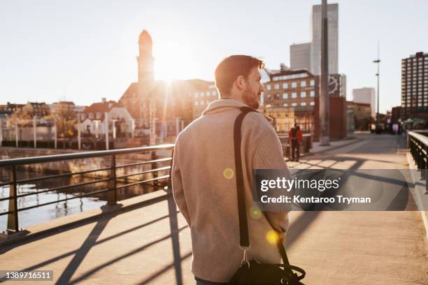 the back of a man facing the back light in city environment - hairy back man stockfoto's en -beelden