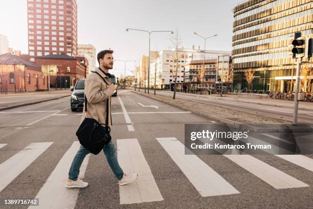 a man at a pedestrian crossing - zebrastreifen stock-fotos und bilder