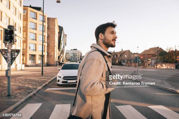 a man at a pedestrian crossing - maletín para portátil fotografías e imágenes de stock