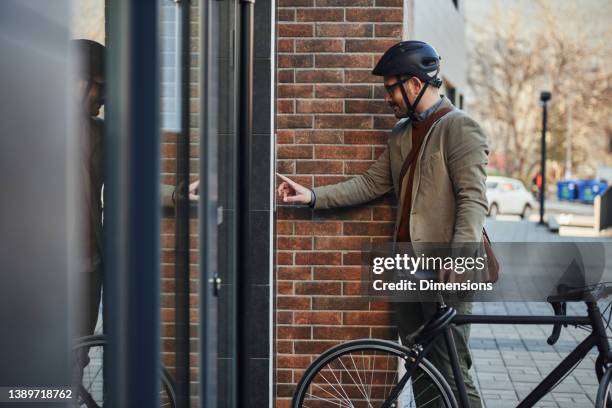 businessman ringing a door bell - deurbel stockfoto's en -beelden