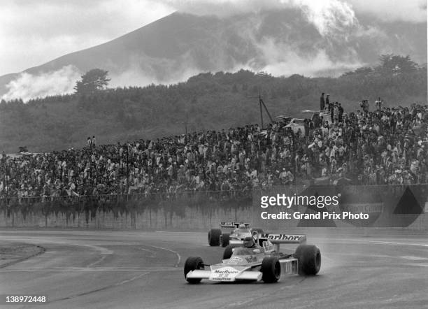 James Hunt of Great Britain drives the Marlboro Team McLaren McLaren M23 Ford Cosworth V8 through the rain and with Mount Fuji in the background...