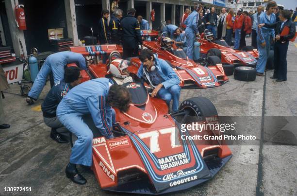 Designer Gordon Murray kneels beside Rolf Stommelen in the as Carlos Pace and Carlos Reutemann sitting aboard their Martini Racing Brabham BT45 Alfa...