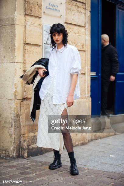 Model and graphic designer Marie Maite wears a white shirt, long tan knit skirt with an open leg, black boots after the Ester Manas show at Espace...