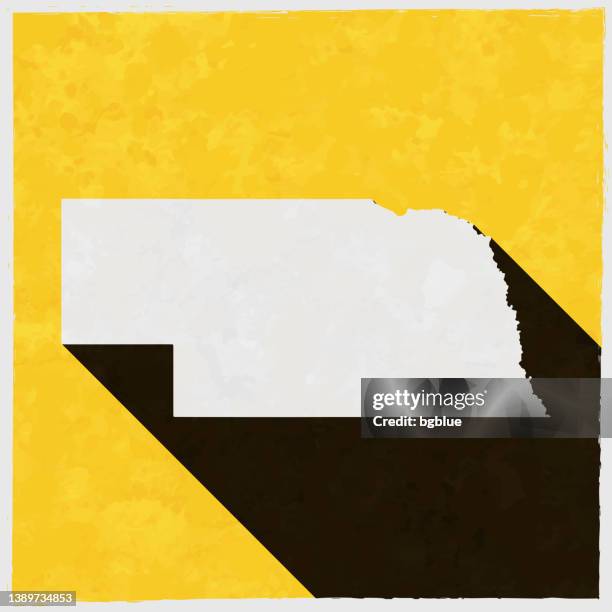 nebraska map with long shadow on textured yellow background - lincoln nebraska stock illustrations