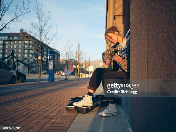 young woman playing guitar in the city - musician stock pictures, royalty-free photos & images