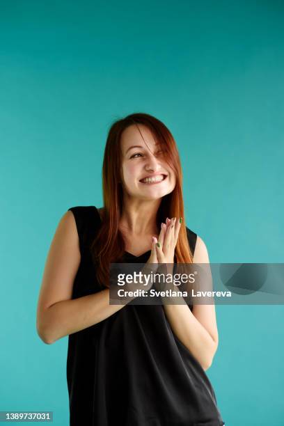 close-up portrait of nice-looking attractive young woman in black top on the blue background. - finger studio close up ストックフォトと画像
