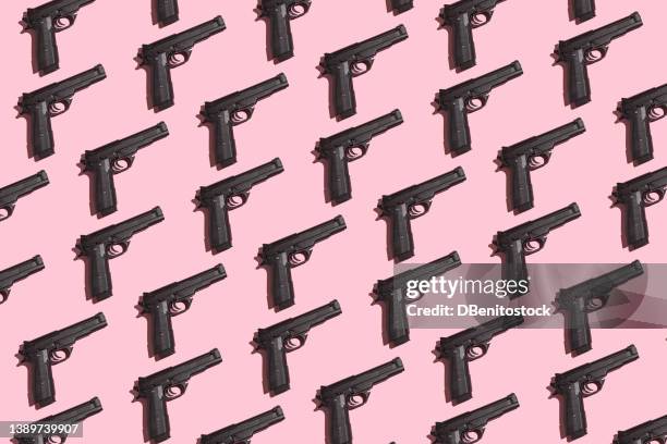 black guns pattern with direct light and hard shadow on pink background. murder, violence, gun, shooting, police, bodyguard, hitman and army concept. - pink pistols stock-fotos und bilder