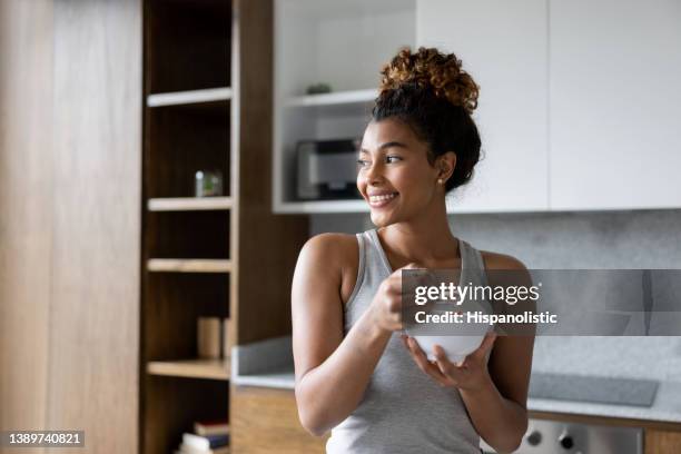 femme heureuse à la maison mangeant un bol de céréales pour le petit déjeuner - yaourt photos et images de collection