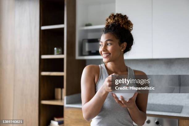 朝食にシリアルのボウルを食べる自宅で幸せな女性 - bowl of cereal ストックフォトと画像