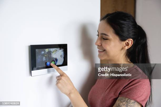 donna a casa usando il citofono - citofono foto e immagini stock