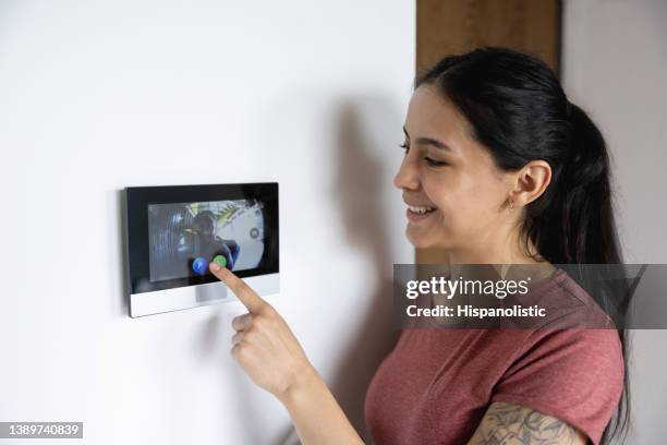 woman at home using the intercom - intercom stock pictures, royalty-free photos & images