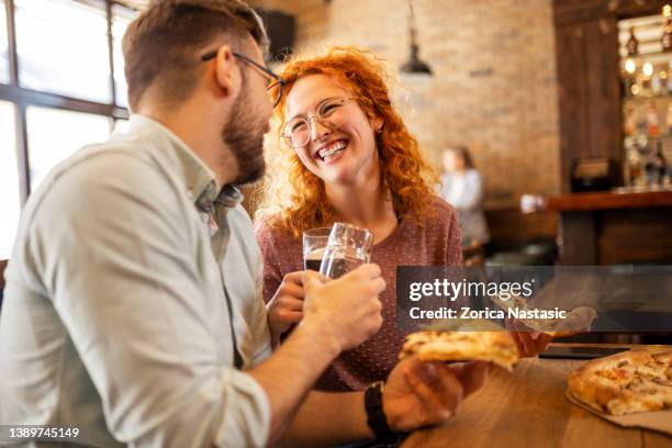 drinking beer in a pub and eating pizza - pizzeria stockfoto's en -beelden