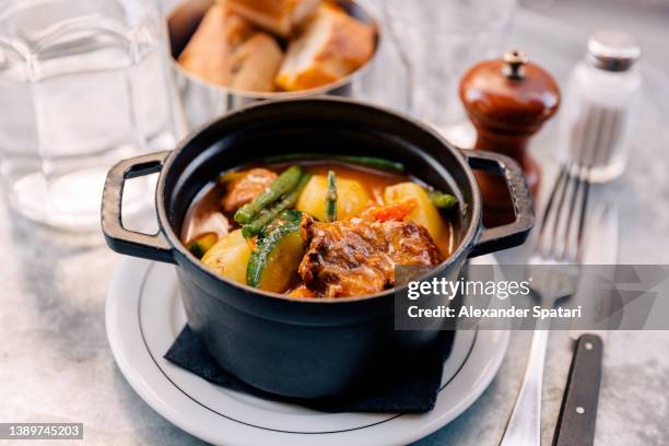 lamb navarin served in a black cast iron casserole, paris, france - lamb stew stock pictures, royalty-free photos & images