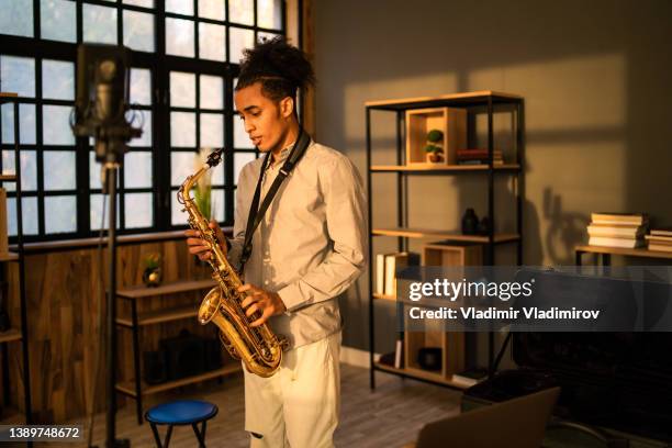 a saxophonist practising in a studio - saxophonist stock pictures, royalty-free photos & images