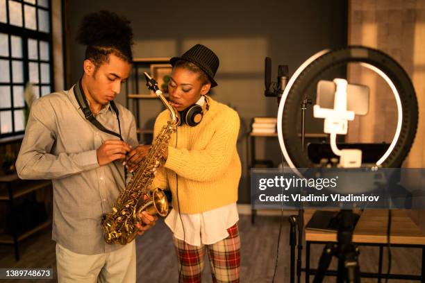 adjusting a saxophone strap before playing - saxophonist stock pictures, royalty-free photos & images