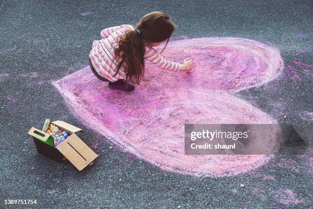 girl makes chalk heart drawing - chalk heart stock pictures, royalty-free photos & images