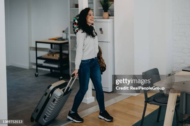 young woman enters a rented apartment - backpacker apartment stock pictures, royalty-free photos & images