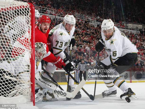 Kari Lehtonen of the Dallas Stars knockes the puck away while Ian White of the Detroit Red Wings is defended by Michael Ryder and Trevor Daley during...