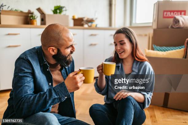 couple moving into new home enjoying a cup of coffee - home sweet home stockfoto's en -beelden