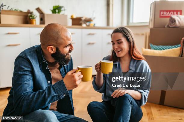 couple moving into new home enjoying a cup of coffee - home sweet home stock pictures, royalty-free photos & images