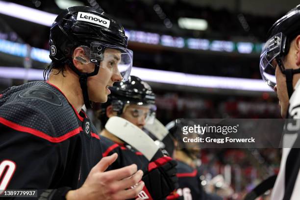 Sebastian Aho of the Carolina Hurricanes discusses a call on the ice with officials during a time out of an NHL game against the Minnesota Wild on...