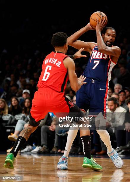 Kevin Durant of the Brooklyn Nets looks to pass as Kenyon Martin Jr. #6 of the Houston Rockets defends during the first half at Barclays Center on...