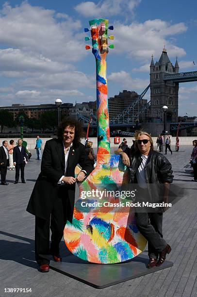 Queen guitarist Brian May and designer Andrew Hewkin pose with a 10-feet tall Gibson Les Paul guitar designed by Hewkin as part of Gibson's...