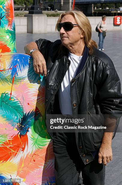 Designer Andrew Hewkin poses with a 10-feet tall Gibson Les Paul guitar designed by Hewkin as part of Gibson's Guitartown London charity event, taken...