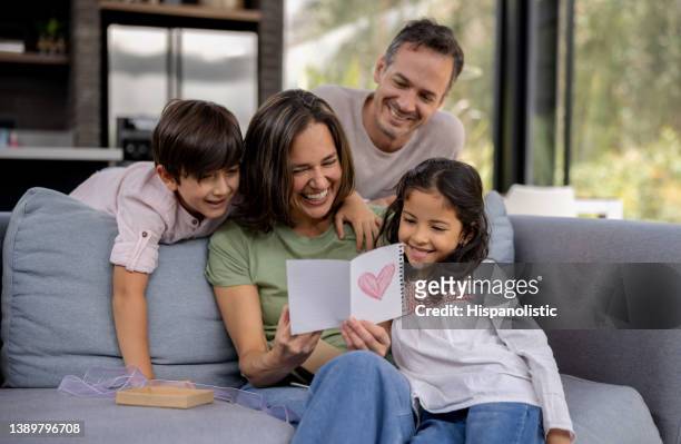 liebevolle familie, die den muttertag zu hause mit einer schönen karte feiert - mothers day stock-fotos und bilder
