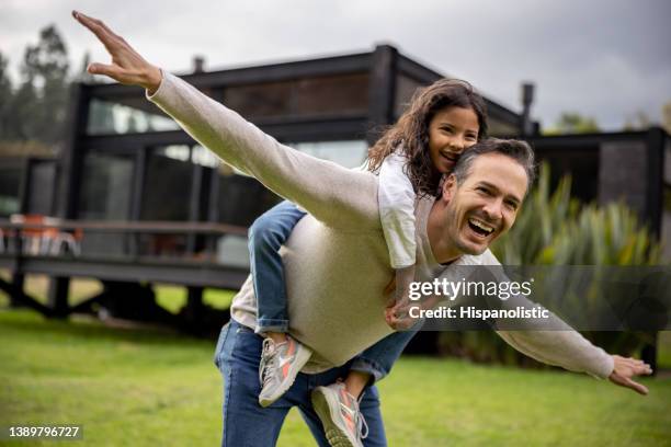 happy father playing airplane outdoors with his daughter - fathersday stockfoto's en -beelden