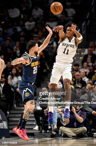 Joshua Primo of the San Antonio Spurs passes as Austin Rivers of the Denver Nuggets defends during the first quarter on Tuesday, April 5, 2022.